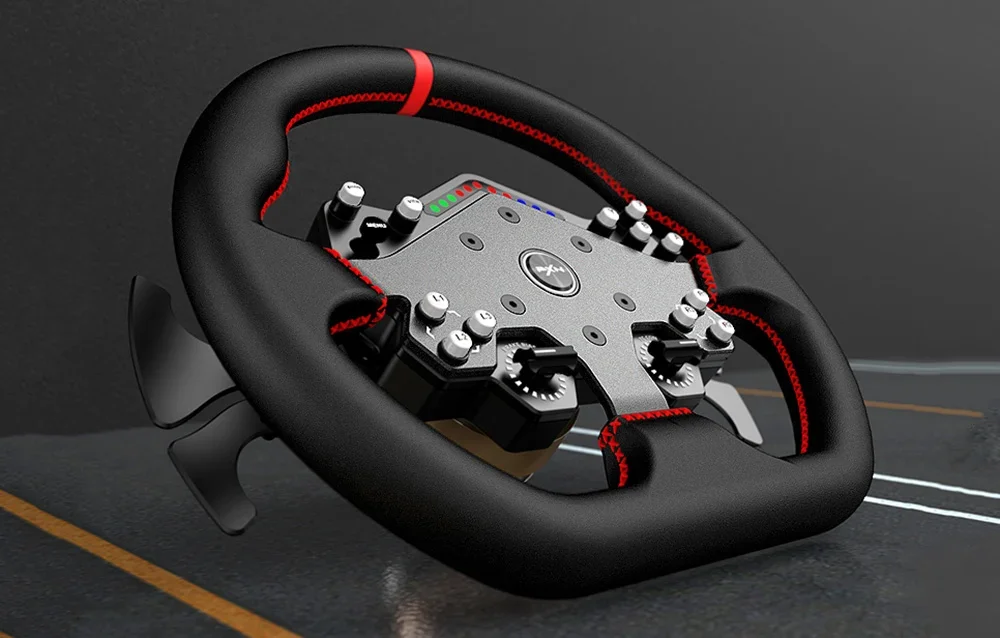 Žaidimų vairas su mygtukais guli ant pilko paviršiaus.