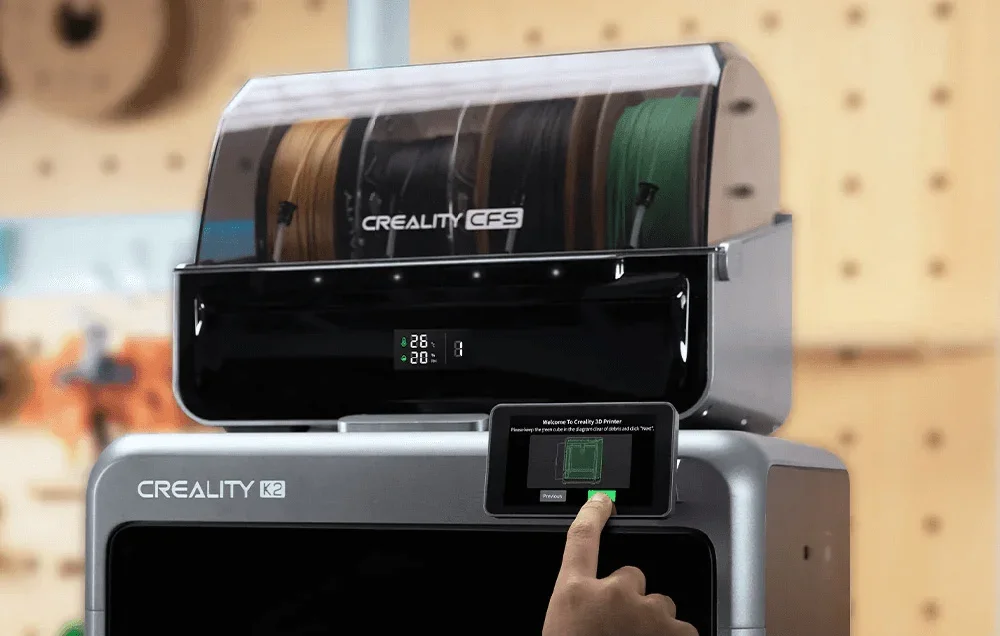 Ranka valdo Creality 3D spausdintuvo jutiklinį ekraną, matoma gijos padavimo sistema