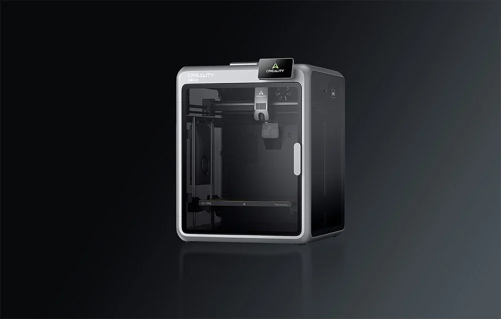 Sidabrinis ir juodas Creality 3D spausdintuvas su skaidriomis sienelėmis tamsiame fone