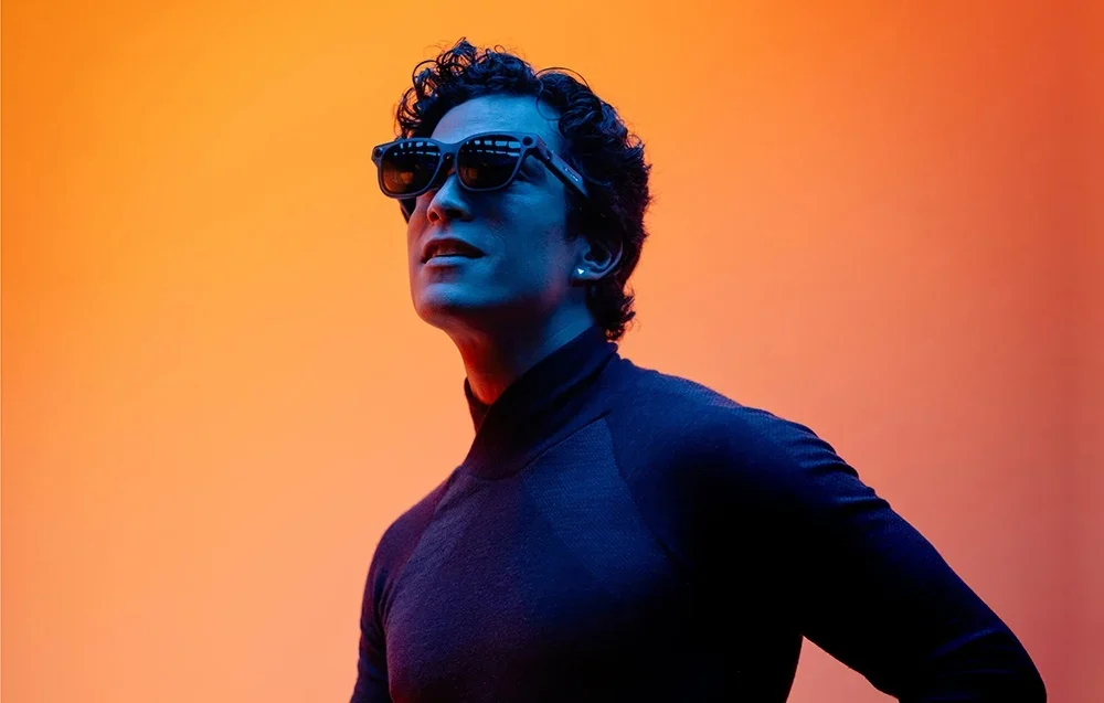 Vyras su XR akiniais oranžiniame fone