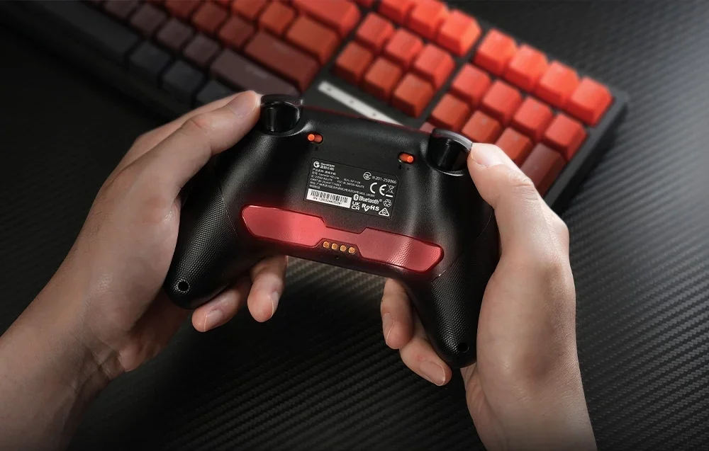 Rear view of the GameSir controller held in the hands, with the label and red inset visible.