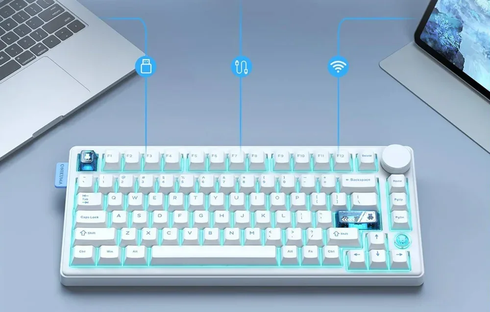 White and blue keyboard on table next to laptop and tablet