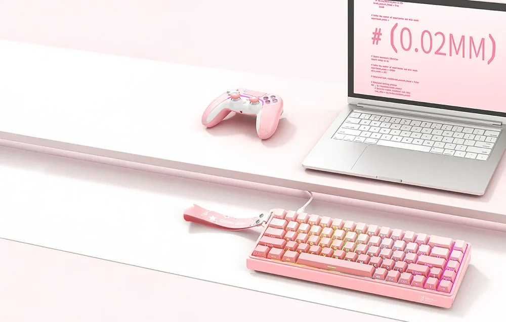 Pink Onikuma keyboard on desk next to laptop and gaming pad