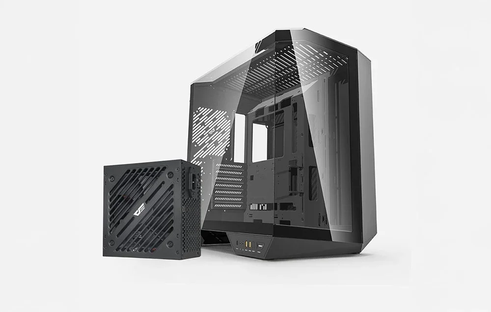 Juodas maitinimo blokas stovi šalia pilko kompiuterio korpuso šviesiame fone