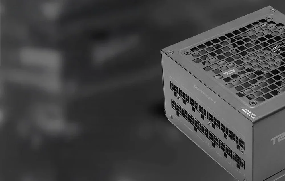 Juodo kompiuterio maitinimo bloko su ventiliacine grotele vaizdas tamsiame fone