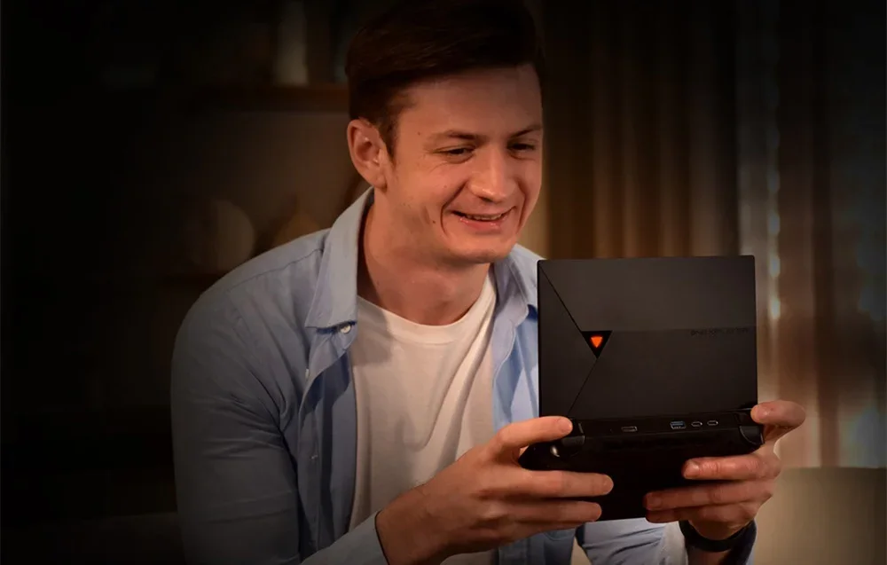 A man playing on a portable game console
