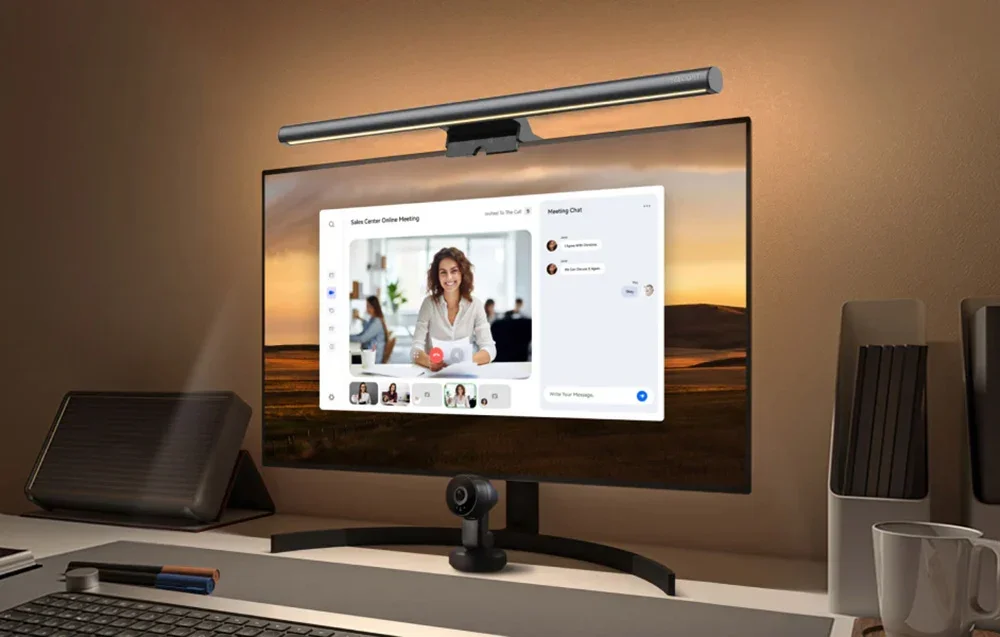 Monitor with light bar lamp during videoconferencing, the screen shows the woman and chat of the meeting