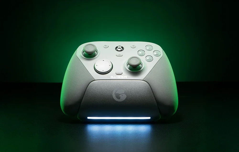 Baltas GameSir valdiklis įkrovimo stotelėje su LED apšvietimu žalios šviesos fone.