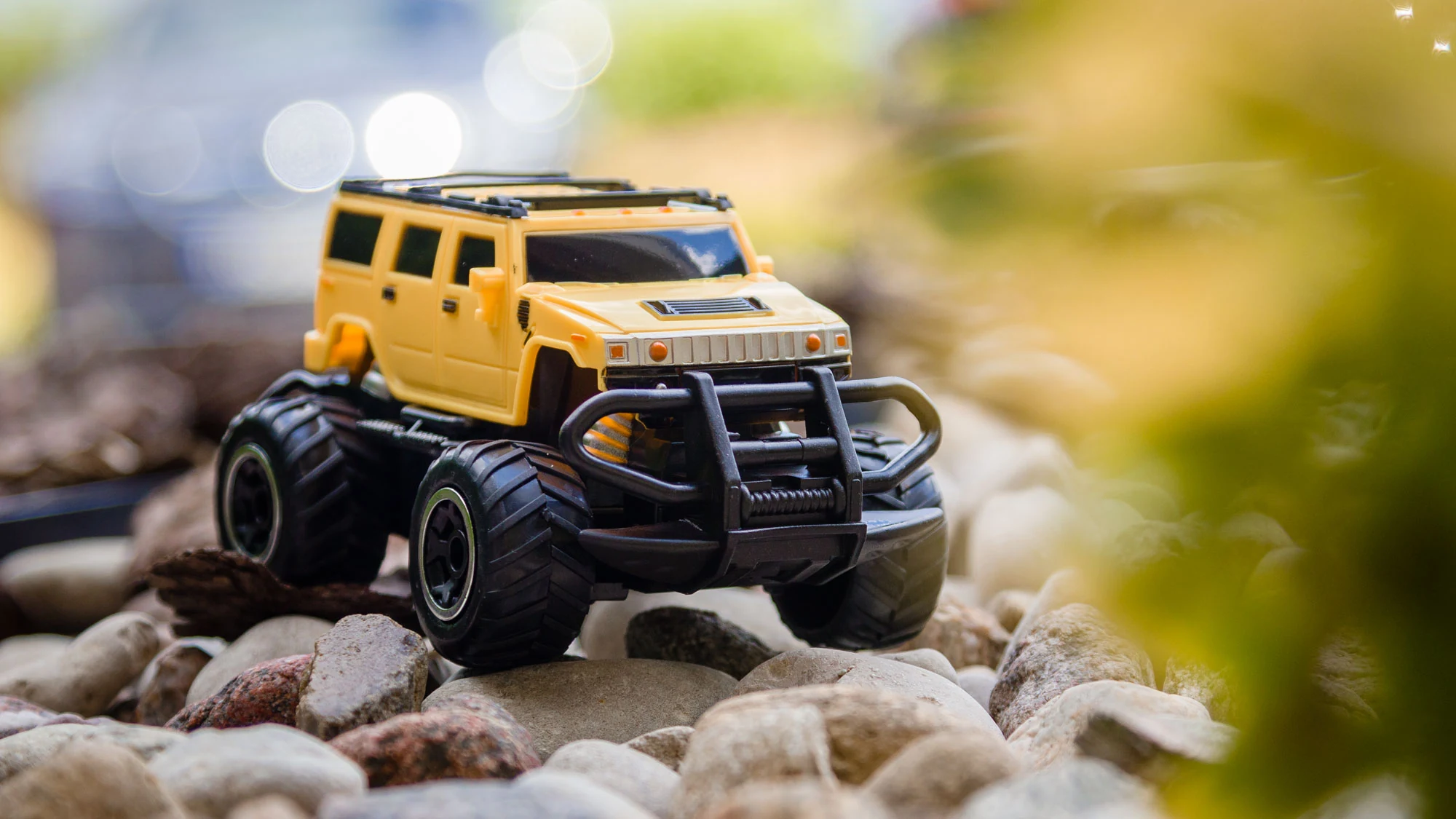 Yellow SUV toy car pictured on rocks
